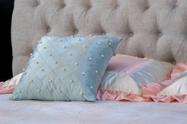 Kahverengi kumaş yastıklı, inci ve pembe kumaş yastıklı modern mavi iç dekorasyon.