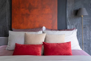 Güzel bir modern kahverengi, kırmızı, bej renkli grup menekşe yatakta kumaş yastıklar ve mermer gri dekorasyon kavramına sahip ayakta duran lamba ampulleri.