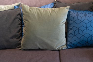 Modern yeşil, kahverengi kumaş yastıklar ve mavi ızgara çizgili tartan çizgili geometrik gingham desenli dekorasyon odası iç mimari konsepti.