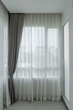Beyaz perdeden güzel bir balkon başkentin iç yüzünü oturma odasından izliyor. Modern ev dekorasyonunu kabul et