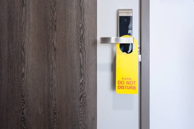 Modern metal kapı kolunda asılı otel tabelasını rahatsız etmeyin. Kendi yazınız ve tasarımınız için çalışma alanı olan ahşap kapı kolunda. Otelin kapalı kapısı kavramı.