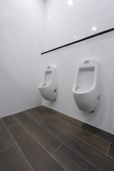 Row of white ceramic urinal chamber pot interior design with beautiful white wall men public toilet or restroom interior modern building decoration concept