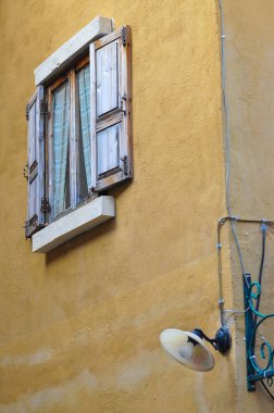 Sarı duvar dış mimari binasında eski ahşap pencere panjuru. Güzel, eski bir ev ve kırsal bir yaşam 