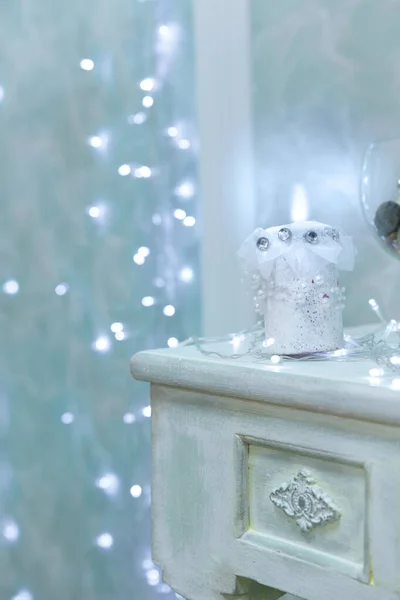 Απαλό ουρανό μπλε Χριστούγεννα φόντο με bokeh και καύση κερί στο προσκήνιο στέκεται στο τραπέζι. Χριστουγεννιάτικο χειμωνιάτικο φόντο. Η έννοια των ευτυχισμένων Χριστουγέννων. — Φωτογραφία Αρχείου
