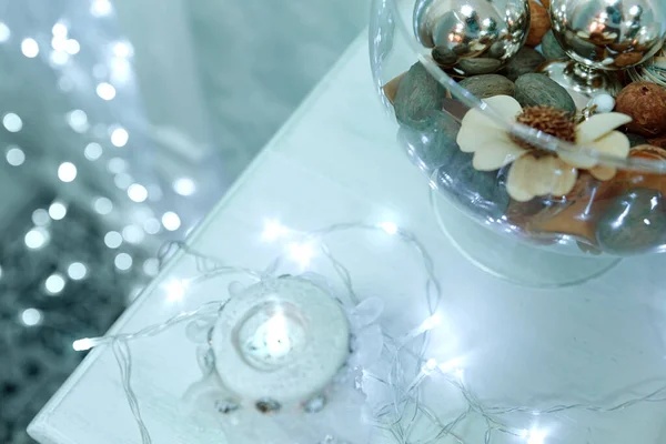 Dolce cielo blu sfondo di Natale con bokeh candela ardente e decorazioni natalizie in piedi sul tavolo. Natale inverno sfondo vista dall'alto. Il concetto di un felice Natale . — Foto Stock