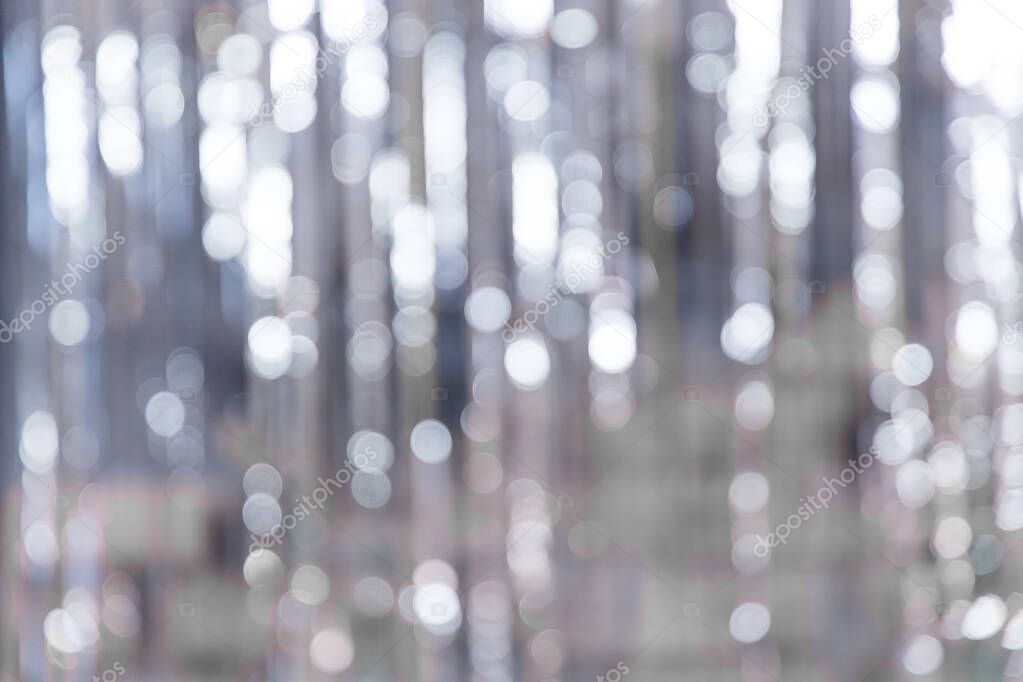 Mysterious Christmas silver defocused background. Silver festive texture with twinkling bokeh stars. Abstract blurred bokeh curtain.