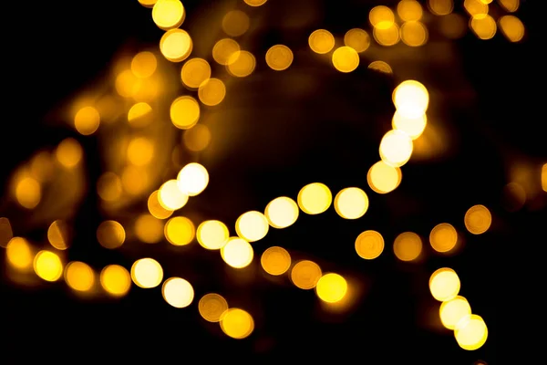 Christmas branches garland with blurred focus in the form of bokeh on a dark background. Abstract colorful background. — Stock Photo, Image