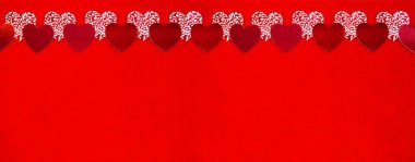 Kırmızı ve beyaz sevgililer günü kalpleri parlak kırmızı kadife arka planda yer almaktadır. Mesaj atmak için çok yer var. Sevgililer Günü tebrik kartı ve uzun afiş. Üst Manzara. Uzayı kopyala Kalp aşkı yaşar.