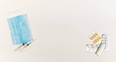 Medical masks, tablets and syringes on a white background top view. Recommendation of virus coronavirus protection and prevention and treatment of colds.