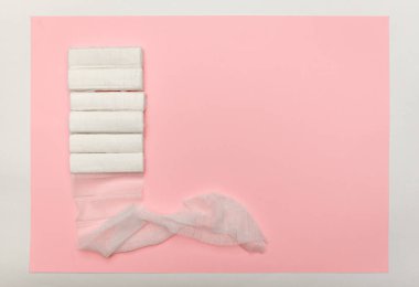 Pembe arka planda sargı bezleri, üst manzara. Yaralanmalar, burkulmalar, çıkıntılar ve çatlaklar için ilk yardım kavramı.