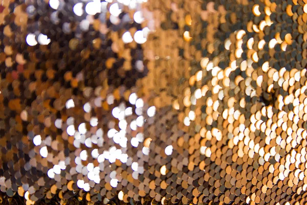 Yellow-gold garlands with a blurred focus in the form of a bokeh. Abstract colorful background with gold bokeh in the form of sequins and fish scales. — Stock Photo, Image