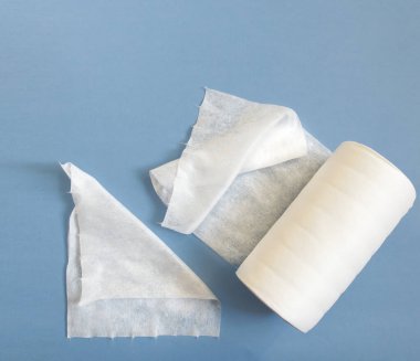 Tek kullanımlık sentetik temiz bezleri mavi arka planda bir rulo içinde. Kozmetik havlular, Spunlace. Kişisel hijyen kavramı