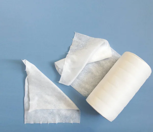 Tek kullanımlık sentetik temiz bezleri mavi arka planda bir rulo içinde. Kozmetik havlular, Spunlace. Kişisel hijyen kavramı