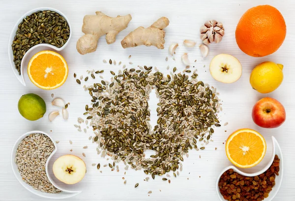 Portakal, zencefil, sarımsak, ıhlamur, limon, kuru üzüm, ayçekirdeği, elma, kabak çekirdeği organik bağışıklık ürünleri, virüslere karşı doğal ilaçlarla mücadele. Doğal ürünlerin arka planı üst görünüm.