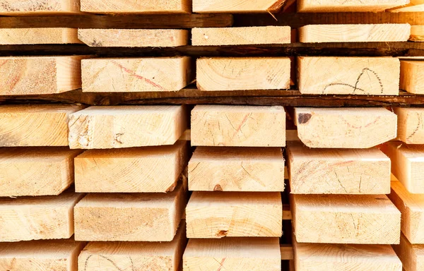 Kereste deposunda bir yığın yeni tahta çivi. İnşaat alanındaki kereste kurumak için. Kesilmiş ve işlenmiş kozalaklı ağaçların arka planı