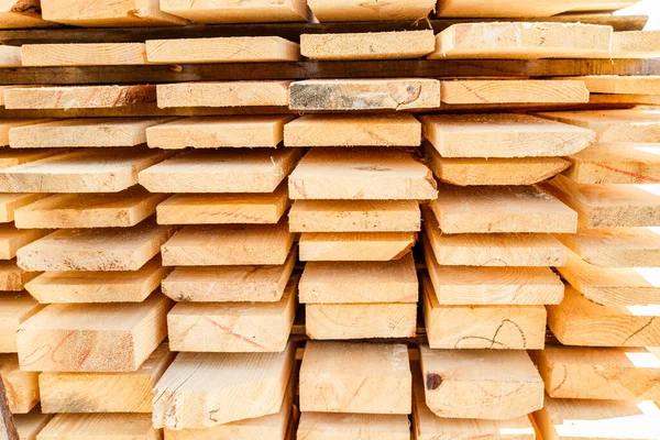 Kereste deposunda bir yığın yeni tahta çivi. İnşaat alanındaki kereste kurumak için. Kesilmiş ve işlenmiş kozalaklı ağaçların arka planı