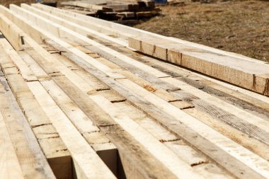 İnşaat alanında kereste ve inşaat kirişleri var. Çatı inşaatına hazırlanılıyor..