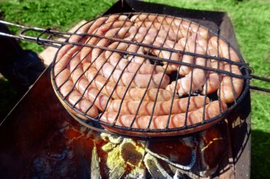Domuz eti ve tavuk sosisi. Mangalda ızgara pişiriyorum, Brezilya usulü. Üst manzara, yakın çekim. Açık havada. Fast food. Açık hava kömür ızgarasında sosis hazırlığı.