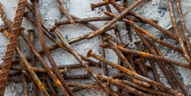 Arka plan paslı çiviler ve açık arkaplan üzerine bulanık seçici odak ile yakın plan demiri.