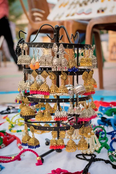 Cercei indieni tradiționali handmade cu fundal încețoșat sunt afișați într-un magazin de stradă de vânzare. Artizanat și artă indiană — Fotografie, imagine de stoc