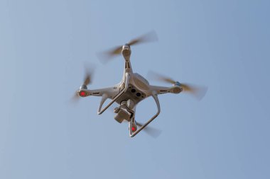 Kameralı modern RC Drone / Quadcopter açık mavi gökyüzünde uçuyor. Aero fotoğraf çekiminde yeni teknoloji.