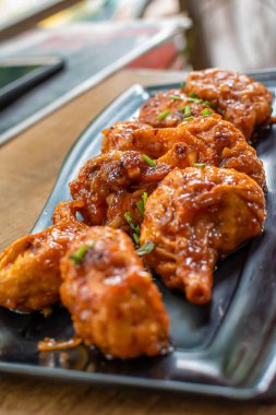 Momo 'nun kızarmış tavuğu kapkara tabakta servis ediliyor. Seçici odak