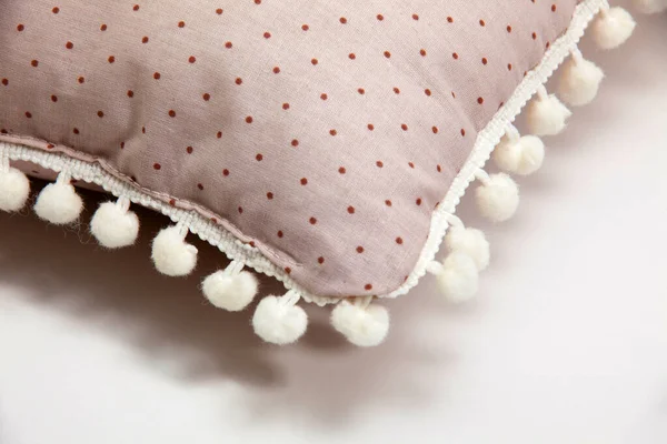 Beyaz zemin üzerinde ponpon ve puantiyeli rahat bej yastık desenleri