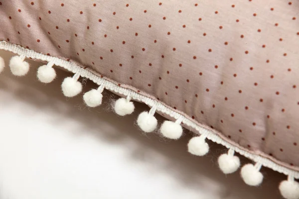 Beyaz zemin üzerinde ponpon ve puantiyeli rahat bej yastık desenleri