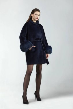 Stüdyoda zarif bir ceketle poz veren güzel moda kadını.