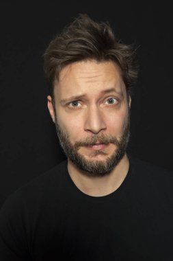 Siyah arka planda sakallı bir adam portresi 