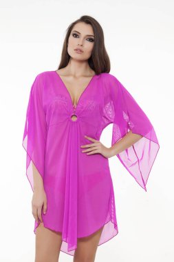 Beyaz arka planda zarif, detaylı, pembe bir pareo ile poz veren güzel bir kız..