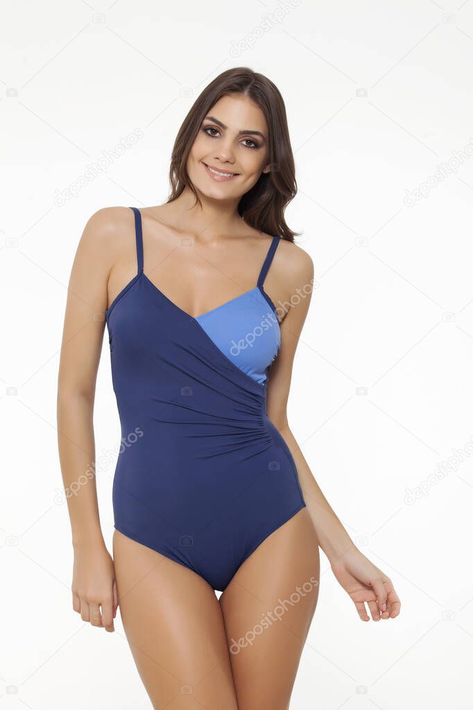 beautiful girl posing in stylish detailed blue swimsuit on white background.