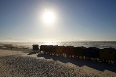 Cape Town 'da güneşli güzel bir gün, kumsalda ve deniz manzaralı renkli kulübeler..