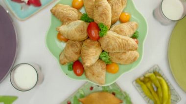 Yakın çekim, yemek masasının üst görüntüsü. Turşu, tavuk pilavı, et, kibbe, hamur işi ve kızarmış sebzeyle pişirilmiş kayısı fasulyesi. Lezzetli, geleneksel Türk aile yemeği masası..
