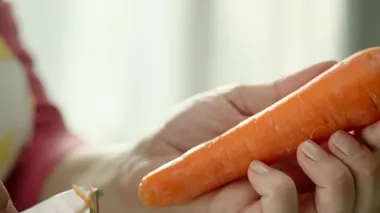 Eller taze havucu sebze kazıyıcısıyla soyuyordu. Yavaş çekim ve hızlı.