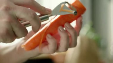 Eller taze havucu sebze kazıyıcısıyla soyuyordu. Yavaş çekim ve hızlı.