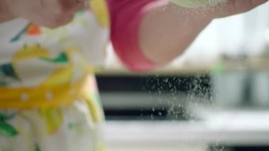 Pişmemiş köftelere un karıştıran bir kadın.