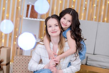 İç kısımda annesi olan kız çocuğu, kıvrımlar, gülümseme.