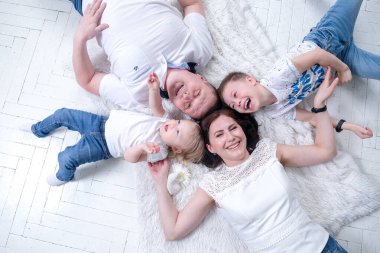 Çocukları olan aile şöminenin yanında oturuyor.