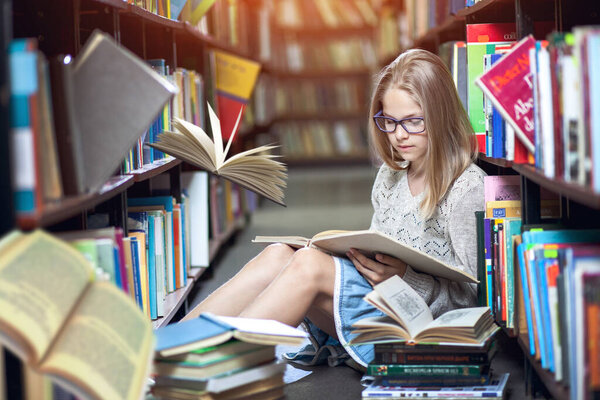 girl reads a book in the library