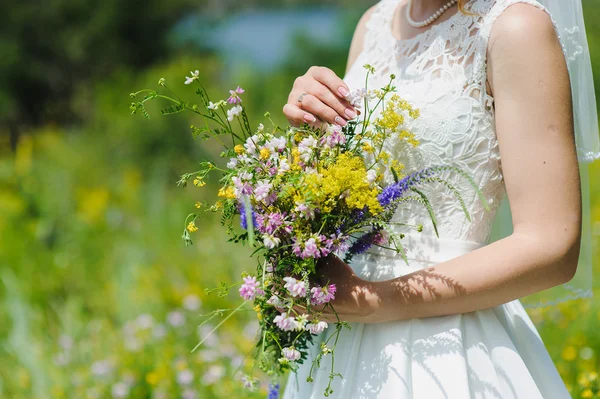 Bride with a bouquet of wildflowers — Stock Photo, Image