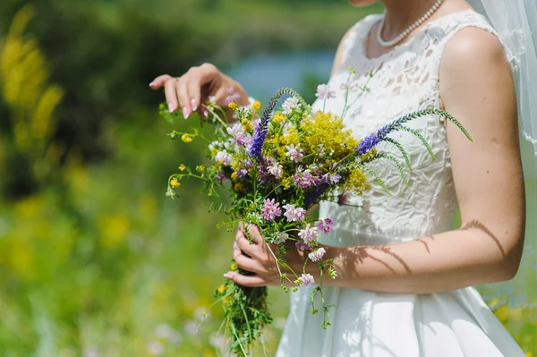 Noiva com um buquê de flores silvestres — Fotografia de Stock