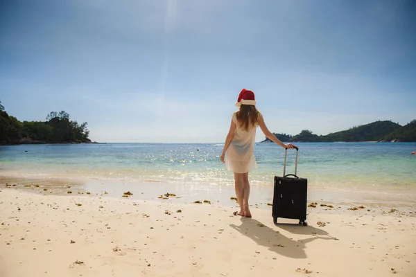 Meisje met een koffer op het strand — Stockfoto