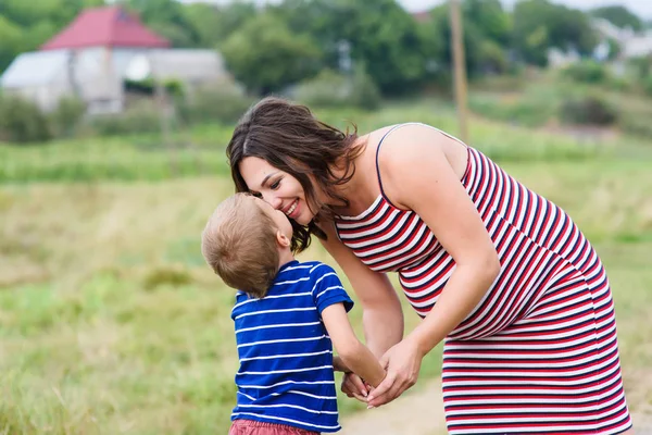 Mujer embarazada besando a su hijo — Foto de Stock