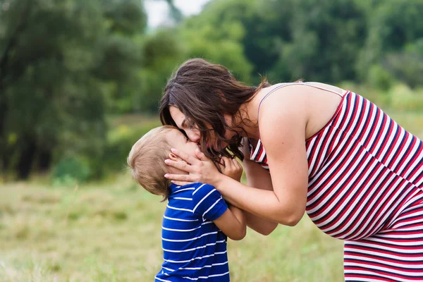 Mujer embarazada besando a su hijo — Foto de Stock