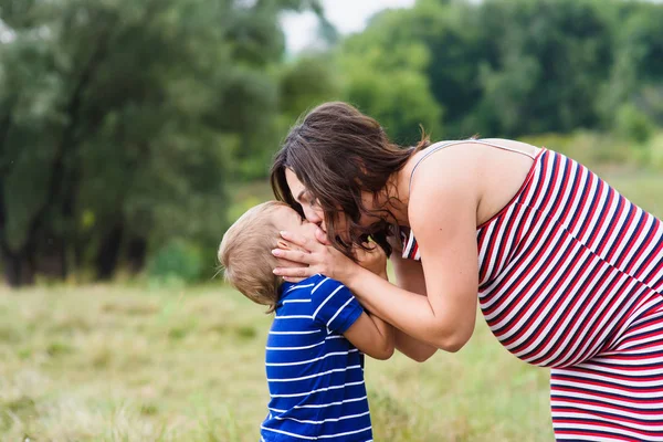 Pregnant woman kissing her son — Stock Photo, Image