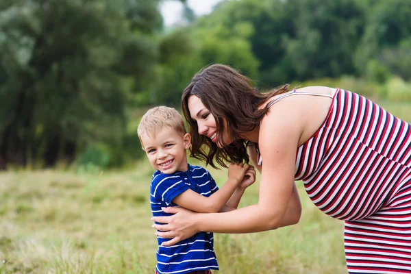 Feliz madre embarazada y su hijo — Foto de Stock