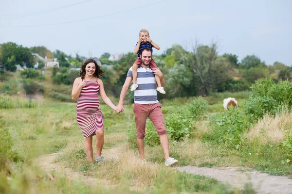Ευτυχισμένη οικογένεια έγκυος γέλιο σε μια βόλτα — Φωτογραφία Αρχείου