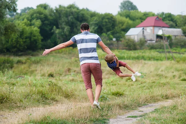 Père jouant et tournant avec son fils dans le parc — Photo