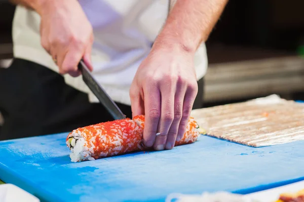 Snijden sushi in stukjes — Stockfoto